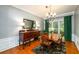 Elegant dining room with a chandelier, hardwood floors, vintage sideboard, and large window overlooking the yard at 515 Rosedown Way, Lawrenceville, GA 30043