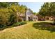 Well-manicured lawn and landscaping surround this two-story home with an attached two-car garage and mature trees at 515 Rosedown Way, Lawrenceville, GA 30043