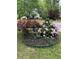 Landscaped yard featuring circular flower bed filled with roses and peonies at 515 Rosedown Way, Lawrenceville, GA 30043