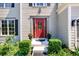 Inviting front entrance with a bright red door, decorative glass, and manicured landscaping with green bushes at 515 Rosedown Way, Lawrenceville, GA 30043