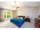 Bright main bedroom featuring a ceiling fan, large window, and en-suite bathroom at 515 Rosedown Way, Lawrenceville, GA 30043