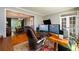 Comfortable home office with hardwood floors, desk, and adjacent dining area with chandelier and lots of natural light at 515 Rosedown Way, Lawrenceville, GA 30043