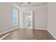 Bright bedroom with neutral walls, wood-look floors, ceiling fan, and double doors to bathroom at 517 Godfrey Dr, Cumming, GA 30040