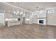 Open-concept living room featuring wood floors, a fireplace, modern lighting and open to the kitchen at 517 Godfrey Dr, Cumming, GA 30040