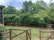 A large, fully fenced backyard with mature trees, offering privacy and a secure outdoor space at 5305 Redfield Way, Cumming, GA 30028