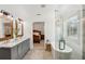 Well lit bathroom with double sinks, a glass shower, modern tub and doorway view to bedroom at 5305 Redfield Way, Cumming, GA 30028