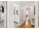 Bright hallway showcasing hardwood floors, white trim, and doorways leading to rooms and a bathroom with stylish features at 5305 Redfield Way, Cumming, GA 30028