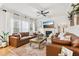 Bright living room with a fireplace, shiplap wall, large leather sectional and light-filled windows at 5305 Redfield Way, Cumming, GA 30028