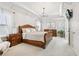 Airy main bedroom with chandelier, white walls, a large bed and bright windows at 5305 Redfield Way, Cumming, GA 30028