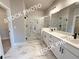 A stunning primary bathroom features a glass shower, double sink vanity, and bright lighting at 5720 Urban Village Way # 7, Tucker, GA 30084