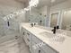 A modern primary bath with marble floors and countertops, dual sinks, and a glass enclosed shower at 5720 Urban Village Way # 7, Tucker, GA 30084