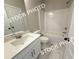A bright bathroom with white marble floors, a single sink vanity, and a shower-tub combo at 5720 Urban Village Way # 7, Tucker, GA 30084