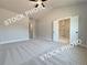 A bright primary bedroom features carpet, neutral paint and trim, and doorways to the bath and closet at 5720 Urban Village Way # 7, Tucker, GA 30084