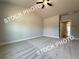 A light filled bedroom has neutral paint, carpet and trim and a view to another room at 5720 Urban Village Way # 7, Tucker, GA 30084