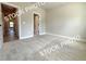 A well-lit bedroom features neutral carpet, paint and trim, and a doorway to another room at 5720 Urban Village Way # 7, Tucker, GA 30084