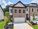 Charming new construction townhome featuring a brick facade and a two-car garage and well-manicured lawn at 5720 Urban Village Way # 7, Tucker, GA 30084