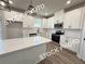 Modern kitchen showcasing white cabinets, stainless steel appliances, and a quartz countertop island at 5720 Urban Village Way # 7, Tucker, GA 30084