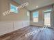 Bright living room showcasing wainscoting detail, wood floors, and a glass panel door at 5720 Urban Village Way # 7, Tucker, GA 30084