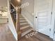 Staircase featuring stained wood treads, white risers, and a decorative black metal railing at 5720 Urban Village Way # 7, Tucker, GA 30084