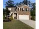 Charming two-story home with a combination brick and vinyl exterior and a well-manicured front yard at 9405 Bandywood Dr, Covington, GA 30014
