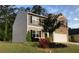 Charming home boasts a manicured lawn, colorful flower beds, and a two-car garage, enhancing its curb appeal at 9405 Bandywood Dr, Covington, GA 30014