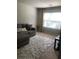 Inviting living room with gray sofa, plush rug, and natural light from a window at 9405 Bandywood Dr, Covington, GA 30014