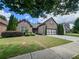 Attractive brick home featuring a well-manicured lawn, mature trees, and a two-car garage at 2826 Staunton Dr, Duluth, GA 30097