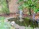 A tranquil backyard pond featuring statues and lush greenery offers a serene outdoor escape at 2826 Staunton Dr, Duluth, GA 30097