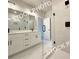 Bathroom featuring double sinks with white cabinets and black hardware, and a glass-enclosed walk-in shower at 5722 Urban Village Way # 8, Tucker, GA 30084
