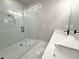 Bathroom featuring double sinks with white countertops, black faucets, and a walk-in shower with glass door at 5722 Urban Village Way # 8, Tucker, GA 30084