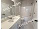 Clean bathroom with white cabinetry, a shower-tub combo, and bright lighting at 5722 Urban Village Way # 8, Tucker, GA 30084