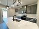 A well-designed kitchen features gray cabinets, stainless steel appliances, and a central island with a white countertop at 5722 Urban Village Way # 8, Tucker, GA 30084