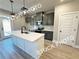 This kitchen showcases gray cabinetry, stainless steel appliances, an island with a white countertop, and sleek pendant lighting at 5722 Urban Village Way # 8, Tucker, GA 30084