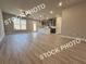 Spacious open-concept living area with wood-look flooring, seamless kitchen, and large windows at 5722 Urban Village Way # 8, Tucker, GA 30084