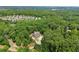 Aerial shot of a luxury home nestled among dense trees in a suburban neighborhood with city views in the distance at 922 Pebblebrook Se Rd, Mableton, GA 30126