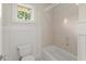 This bathroom showcases a tub and shower combination with white wainscotting at 922 Pebblebrook Se Rd, Mableton, GA 30126