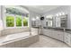 Bright bathroom featuring a large soaking tub under a window, granite counters and double sinks at 922 Pebblebrook Se Rd, Mableton, GA 30126