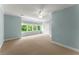 This large bedroom features soft blue walls, carpet, a ceiling fan and a wall of windows at 922 Pebblebrook Se Rd, Mableton, GA 30126