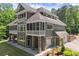 Stately home with gray siding, a screened porch, stone accents, and attached garage amid lush greenery at 922 Pebblebrook Se Rd, Mableton, GA 30126