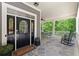 Inviting covered porch with a stone floor, seating, ceiling fan and classic rocking chairs at 922 Pebblebrook Se Rd, Mableton, GA 30126