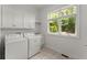 Well-lit laundry room with washer, dryer, sink, and storage cabinets, providing a functional and organized space at 922 Pebblebrook Se Rd, Mableton, GA 30126