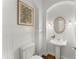 Charming powder room with wainscoting, decorative mirror, and pedestal sink at 922 Pebblebrook Se Rd, Mableton, GA 30126