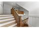 Elegant staircase with wooden banister, white risers, and decorative molding, seamlessly connecting the home's levels at 922 Pebblebrook Se Rd, Mableton, GA 30126