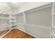 Bright walk-in closet featuring custom shelving, rods, and hardwood floors, maximizing storage and organization at 922 Pebblebrook Se Rd, Mableton, GA 30126
