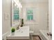 Bright bathroom with a modern sink, large mirror, tub, and stylish black and white floor tiles at 3344 Ridgecrest Dr, Powder Springs, GA 30127