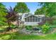Charming backyard with a screened porch, a small pond, and well-maintained landscaping at 4842 Mcpherson Ne Dr, Roswell, GA 30075