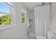 Bathroom featuring a shower with herringbone tile and a window view at 4842 Mcpherson Ne Dr, Roswell, GA 30075