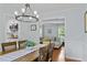Bright dining room with modern light fixture and hardwood floors. A view into the living room at 4842 Mcpherson Ne Dr, Roswell, GA 30075