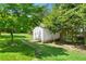 Backyard shed in a lush backyard with green grass and mature trees at 4842 Mcpherson Ne Dr, Roswell, GA 30075