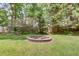 Private backyard oasis with a stone fire pit, perfect for outdoor gatherings and relaxation at 1588 Peachtree Cir, Lawrenceville, GA 30043